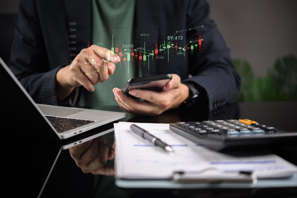 Businessman,Holding,Smartphone,With,Digital,Stock,Market,Candlestick,Chart.,Mobile